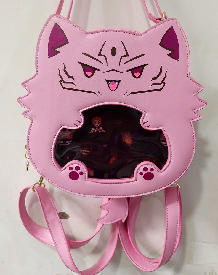 An itabag featuring everyone's favorite curse cat! This ita bag is made with pu leather as well as cotton insides for a sturdy exterior and a soft interior.  It comes with one main storage compartment as well as 4 internal pockets: one large padded pocket, two smaller open pockets, and one zipper pocket. Itabag Size: 9" x 9" x 3" (14" total with tail and ears) The ita bag includes:  - 1 Removable tail  - 1 Crossbody strap - 2 Backpack style straps - 1 Removable purple insert For extra inserts or Gojocat bag, please check out my other shop listings! Harajuku School Bag With Cat Design, Kawaii Shoulder Bag With Cat Design For Daily Use, Kawaii Cat Design Shoulder Bag For Daily Use, Kawaii Cat Design Backpack For Everyday Use, Cat Design Crossbody Travel Bag, Kawaii Tote Bag With Cat Design, Kawaii Cat Design Tote Bag, Pink Backpack With Cat Design, Pink Cat Design Standard Backpack