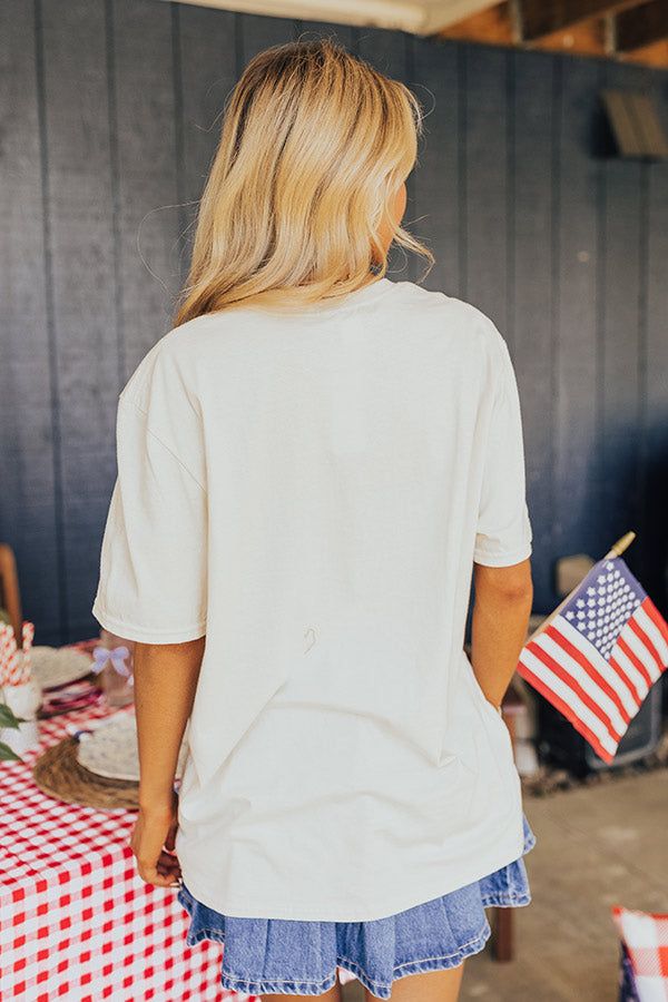 – Light up the skies this summer in our casual but cute tee – Lightweight cotton material with a red and blue patriotic graphic design – Round neckline – Short loose sleeves – Slouched silhouette that falls into a straight unfinished hemline Beige Crew Neck Top For Vacation, Beige Cotton T-shirt For Summer, Casual Soft-washed Cream Top, Casual Cream Soft-washed Top, Soft-washed Cotton Cream Tops, Casual American Flag Print Top For Vacation, Beige T-shirt For Summer Day Out, Beige Summer T-shirt For Day Out, Cream Crew Neck Top For Vacation