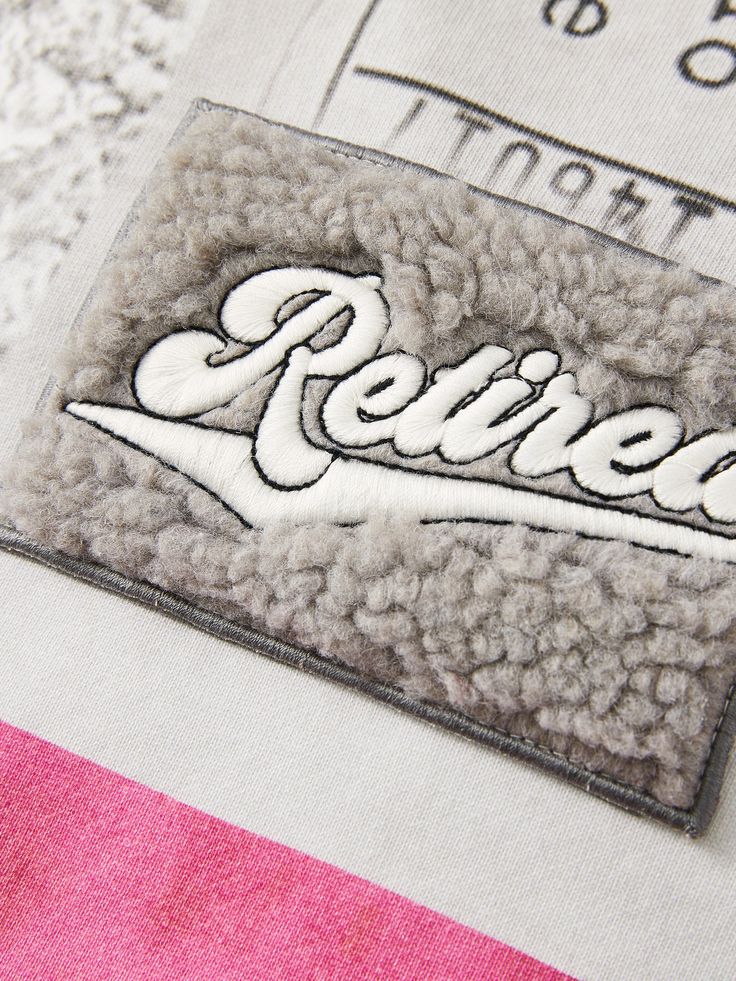 a patch with the word retired on it sitting on top of a piece of fabric