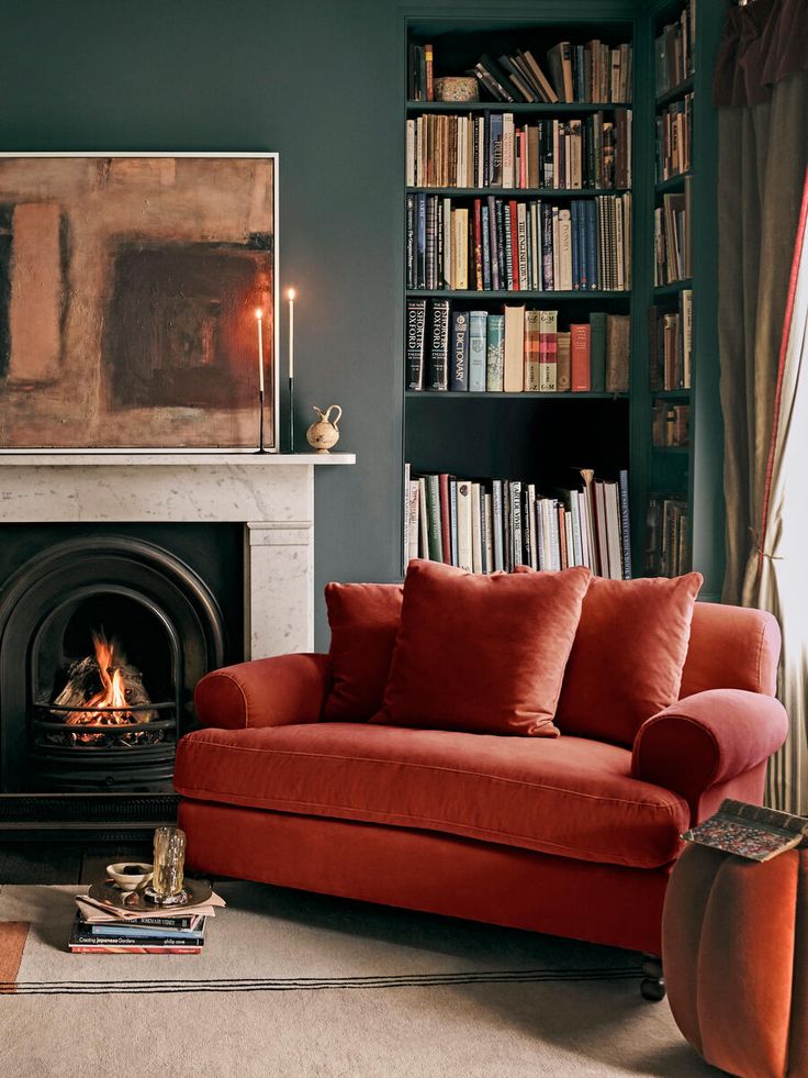 a living room with a couch, fireplace and bookshelf filled with lots of books