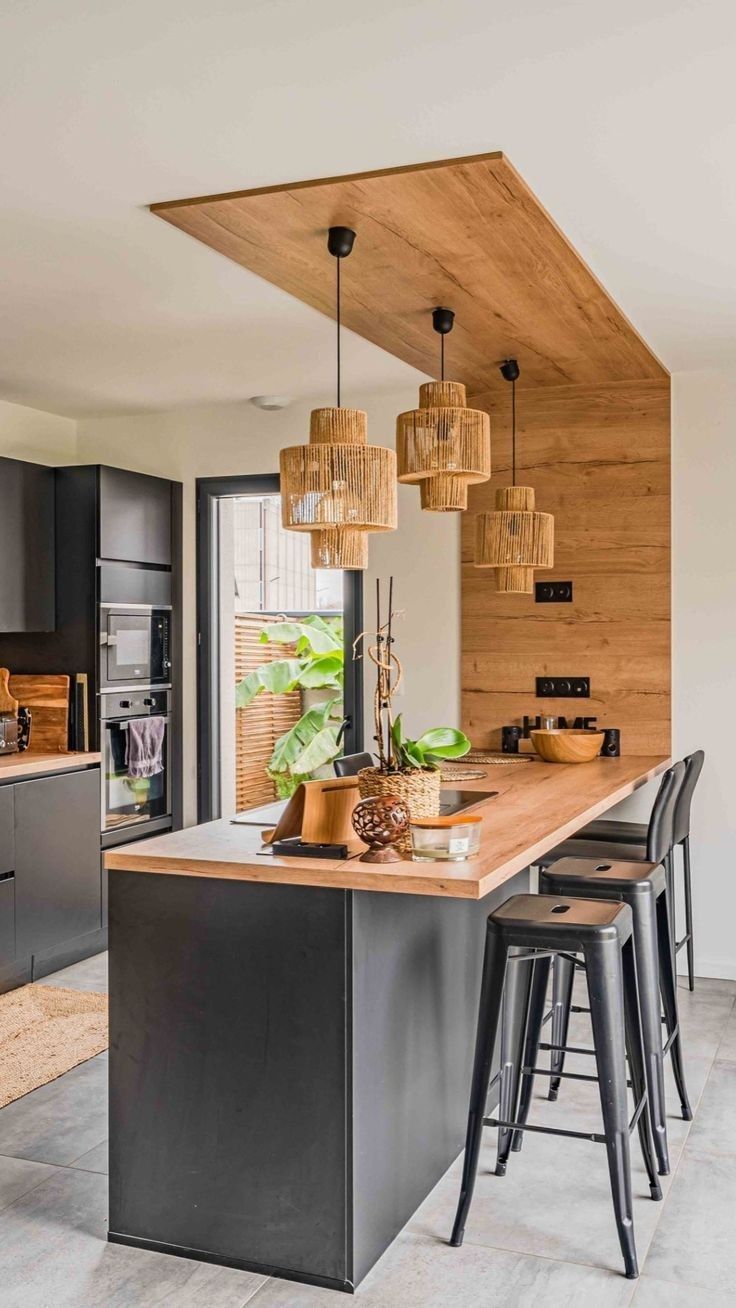 a kitchen with an island and stools in the center, surrounded by wooden accents