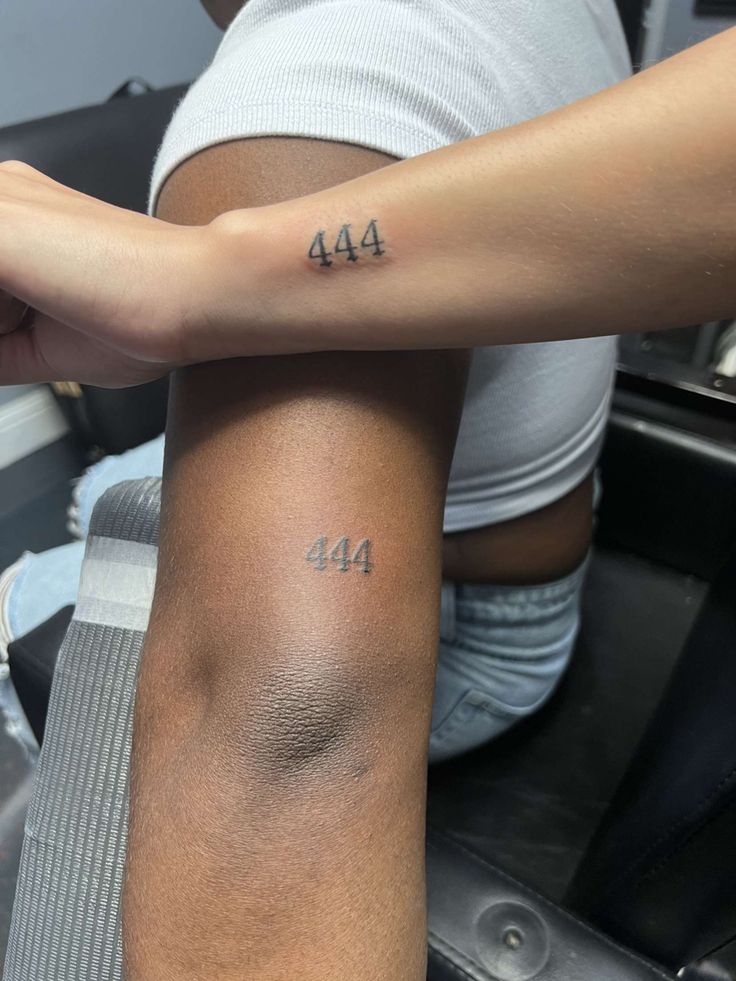 two people with tattoos on their arms and one has the number 414 tattooed on it