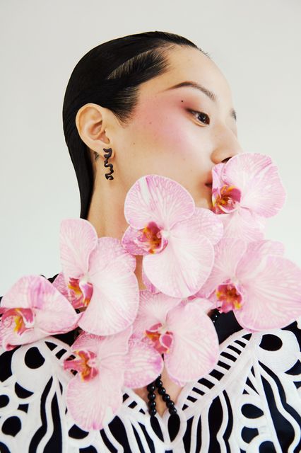 a woman with pink orchids on her neck