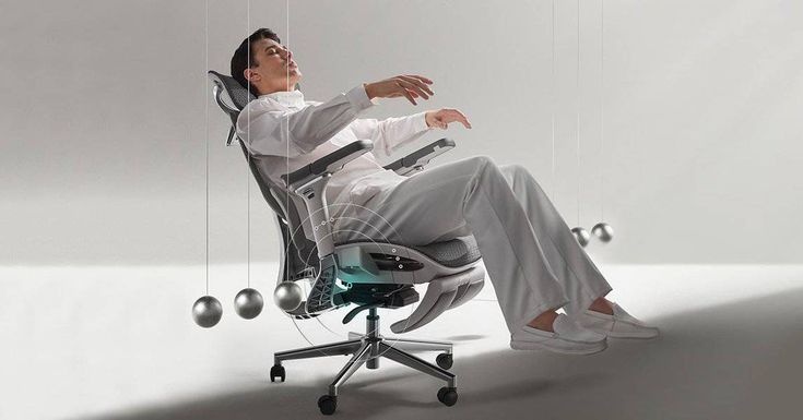 a man sitting in an office chair with balls hanging from the ceiling