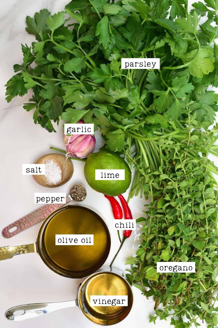 the ingredients for an apple cider recipe laid out on a white surface with green leafy vegetables