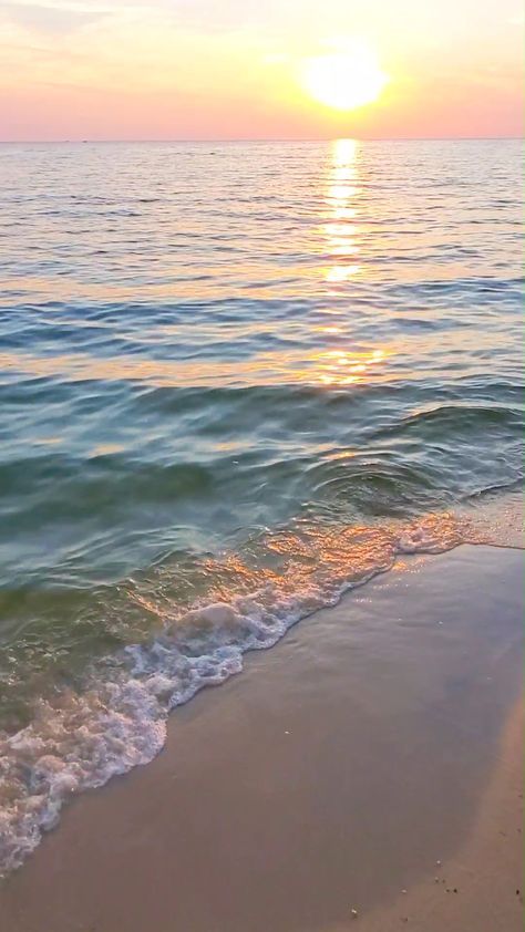 the sun is setting over the water at the beach