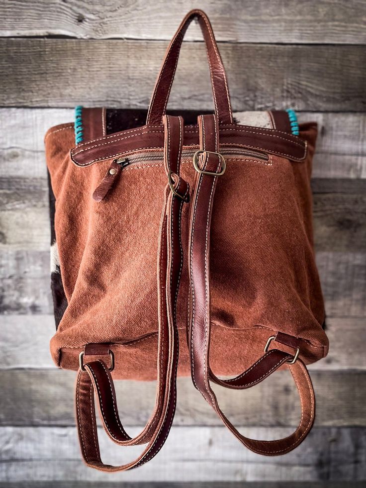 a brown handbag hanging on a wooden wall