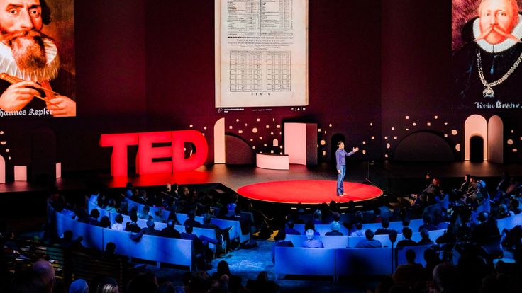 a man standing on top of a stage in front of a crowd