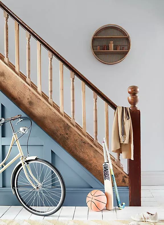 a white bicycle parked in front of a stair case next to a wooden banister