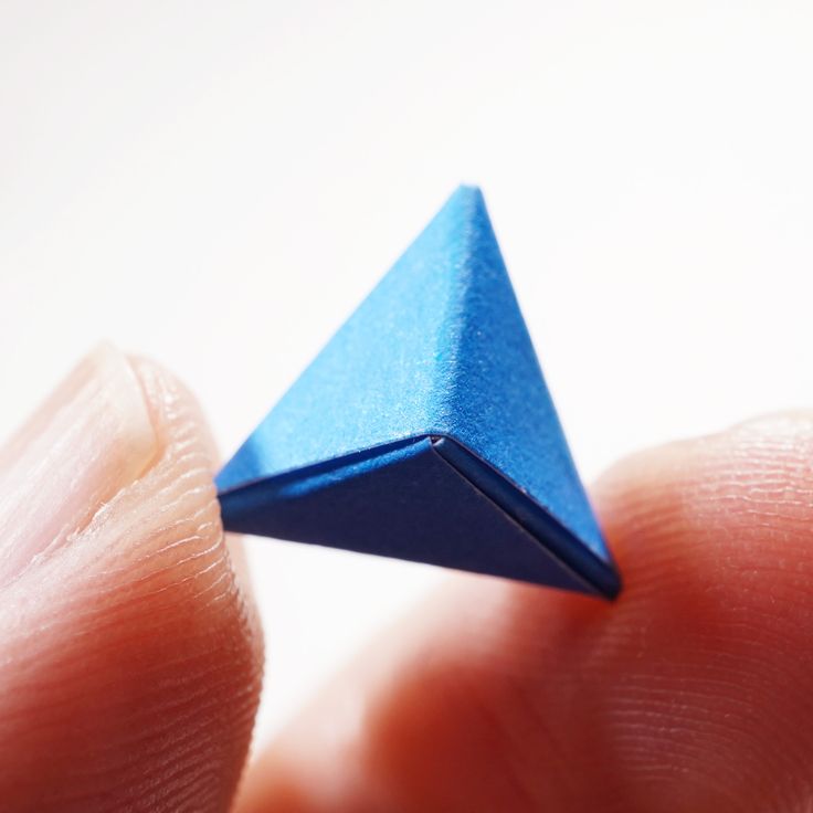 a small blue origami piece being held in someone's hand