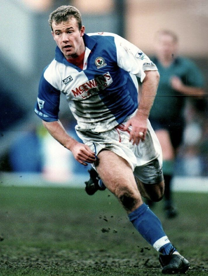 a man running with a soccer ball in his hand on the field during a game