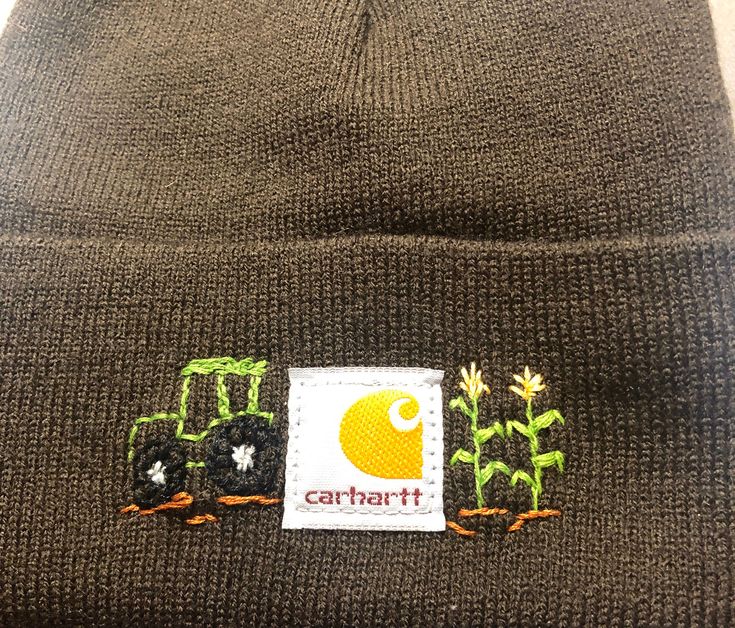 a beanie hat with an embroidered patch on the front and side of it that says, carhart