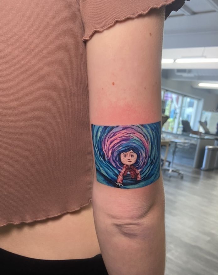 a woman with a tattoo on her arm has a small girl in the middle of a wave