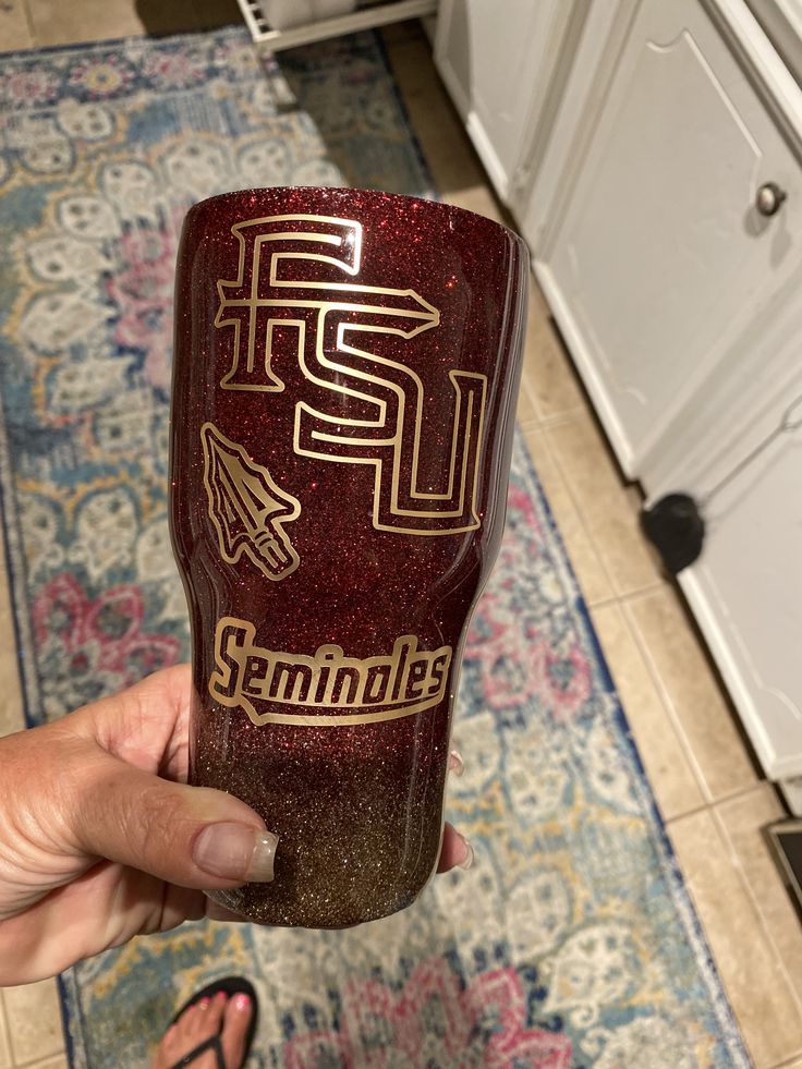 someone is holding up a glass with the san francisco state logo on it