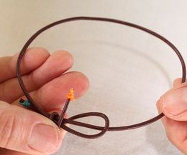 two hands are holding wires in the shape of a circle with an orange star on it