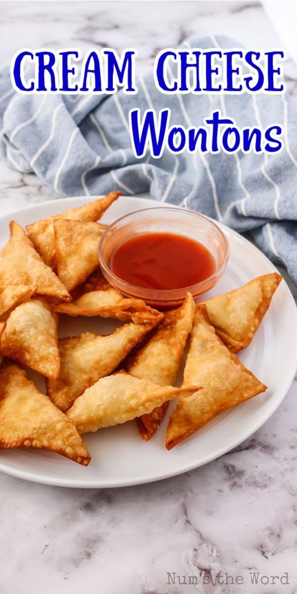 a white plate topped with cheesy wontons next to ketchup