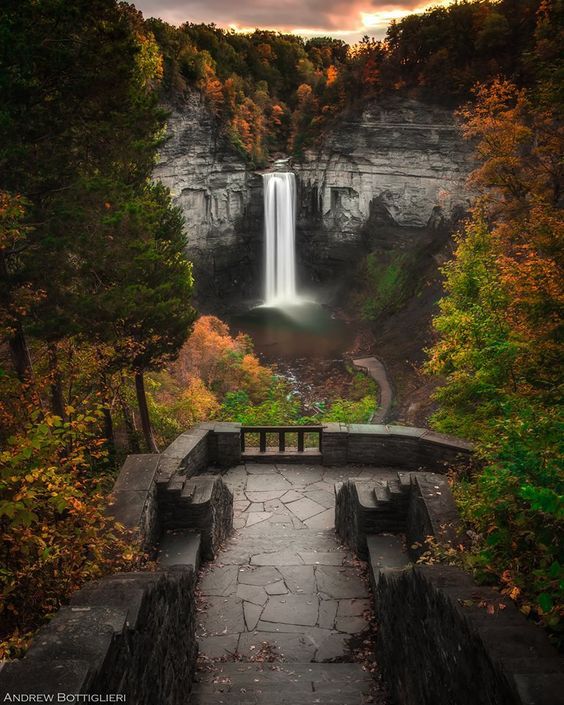 a waterfall is seen through the trees in this artistic photo