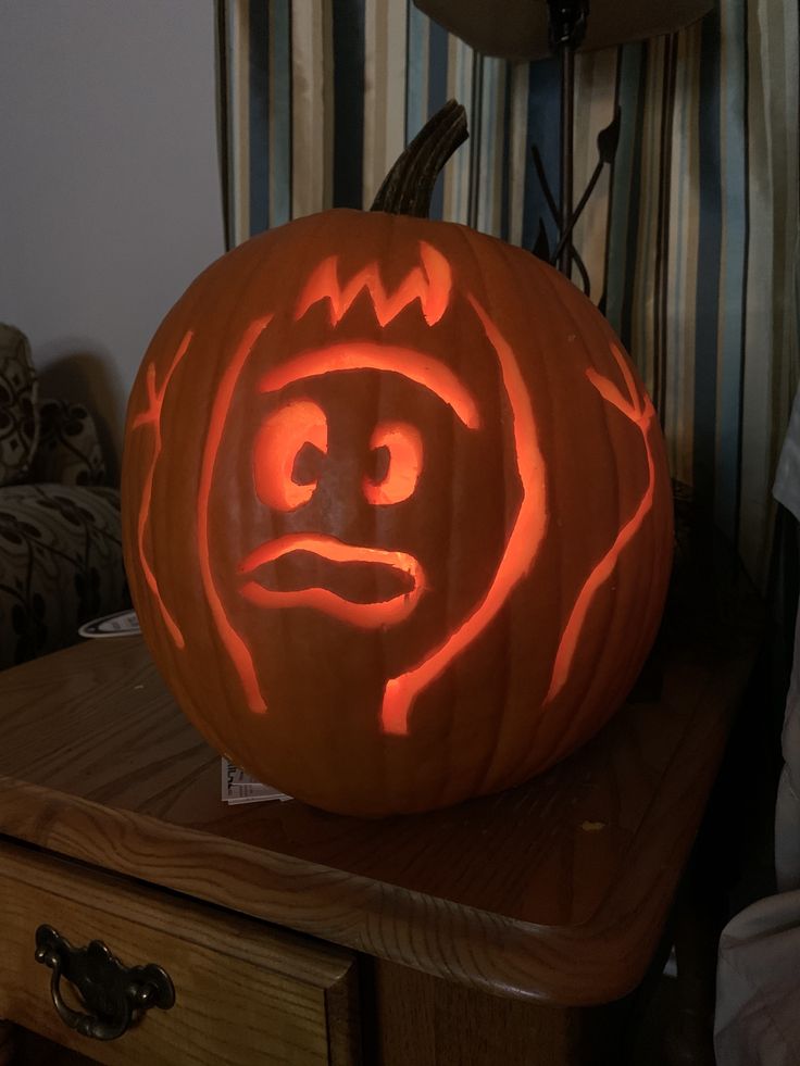 a carved pumpkin sitting on top of a wooden table