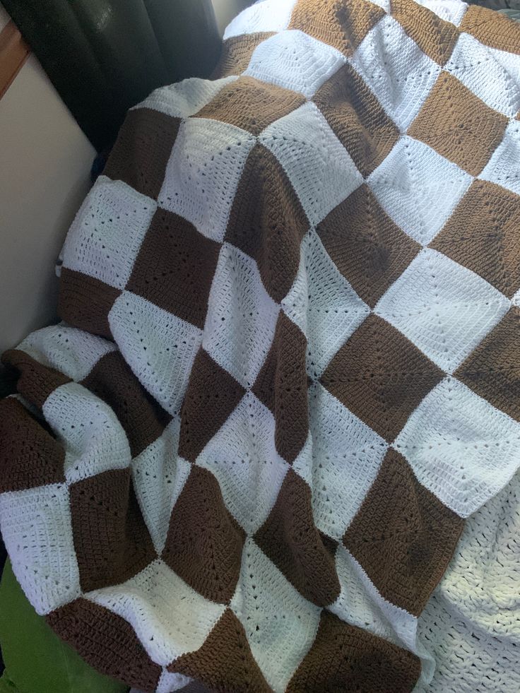 a brown and white blanket sitting on top of a bed