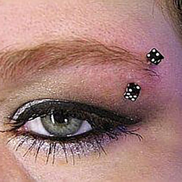 a close up of a person with black and white dots on their eyeliners