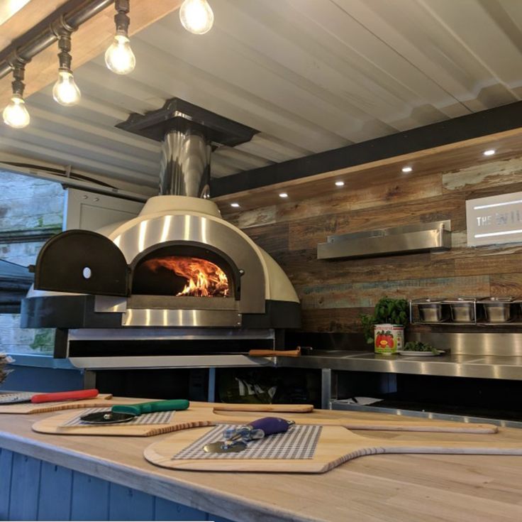 a wood burning oven sitting on top of a counter