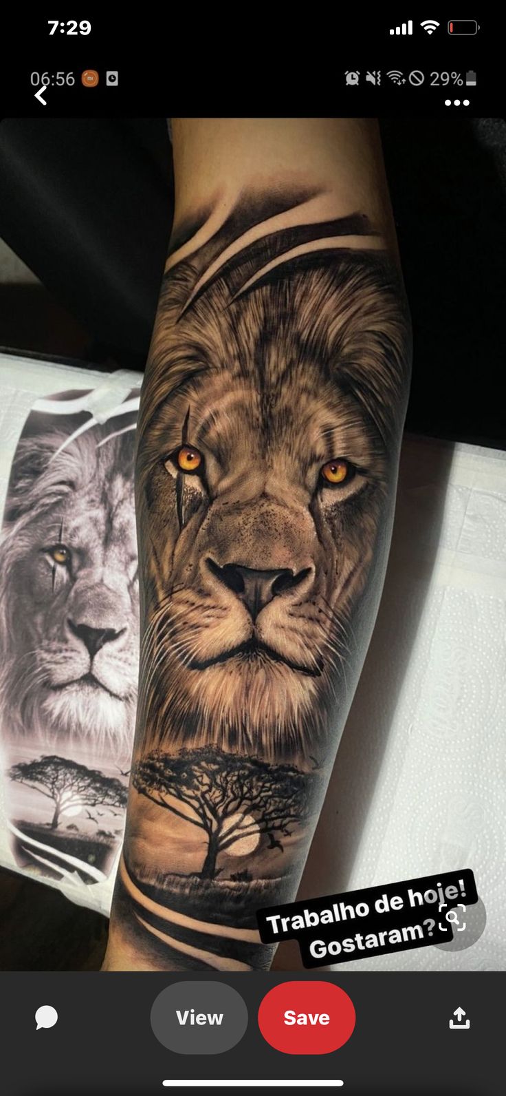 a man's arm with a lion and tree tattoo on it