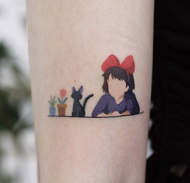 a woman's arm with a cat and flower tattoo on the left side of her body