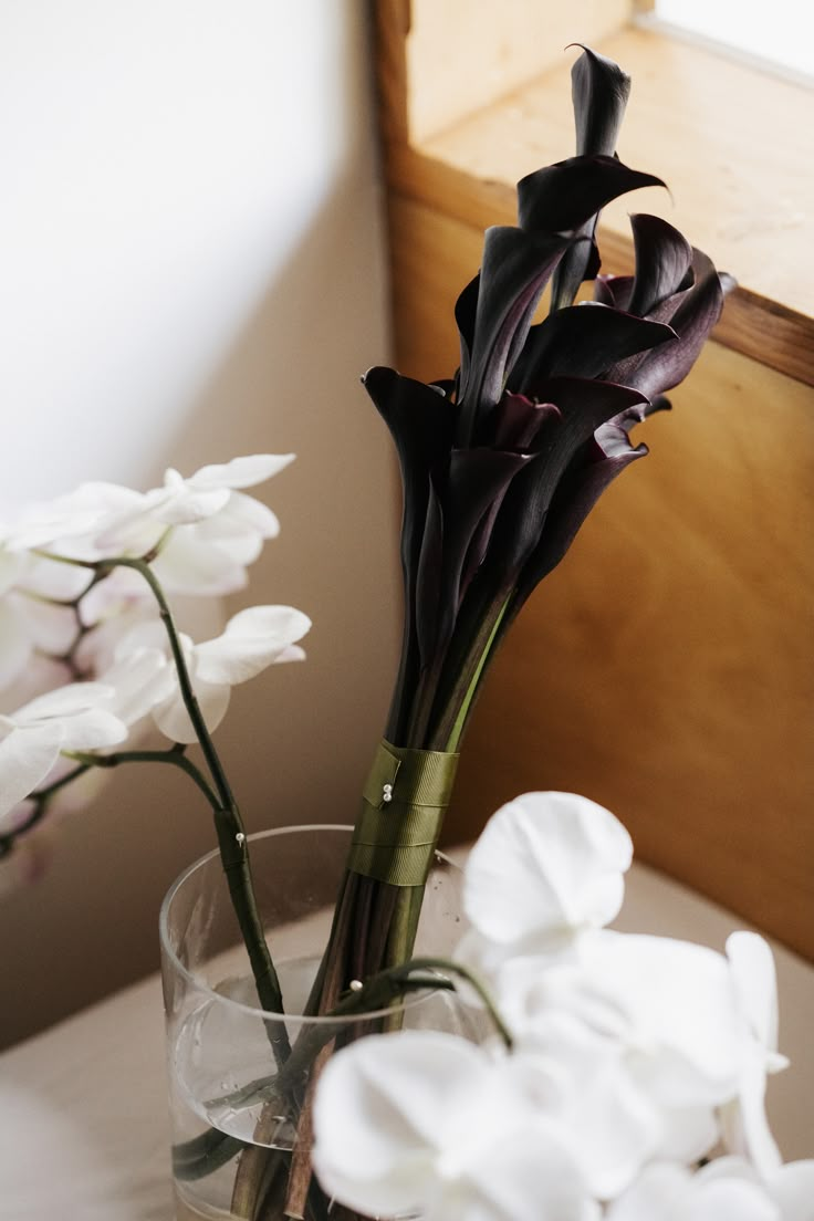 two vases with flowers in them sitting on a table