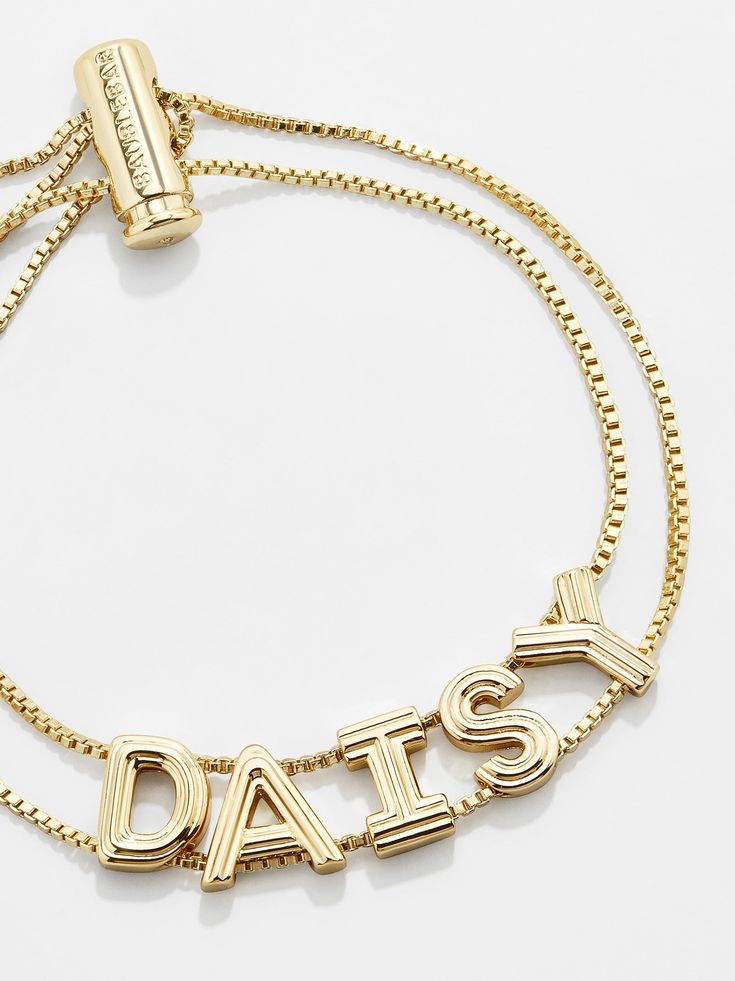 For those who love gold, our Custom Slider Bracelet: Textured Gold is the custom bracelet pick for you. Two strands of box chain sit beneath letter beads of your choice and are topped off with an easy-to-adjust pull-tie closure. Even better? Each bead is crafted in a chic gold hue and features etched grooves, giving each letter extra dimension. Choose a name, initials, or favorite phrase to customize your bracelet with - it's sure to be your new everyday staple. See our Letter Key for all option Adjustable Yellow Gold Name Bracelet, Adjustable Yellow Gold Name Jewelry, Adjustable Nameplate Bracelet For Friendship, Adjustable Nameplate Bracelets For Friendship, Personalized Adjustable Yellow Gold Charm Bracelet, Personalized Yellow Gold Charm Bracelet With Adjustable Fit, Trendy Adjustable Jewelry With Custom Name, Adjustable Nameplate Bracelet For Everyday Wear, Personalized Yellow Gold Charm Bracelet Adjustable