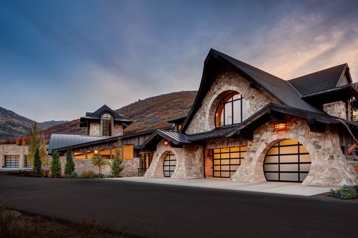 a large stone house with two garages on the front and one above it's windows