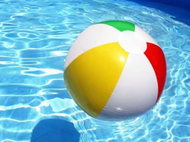 an inflatable beach ball floating on top of a swimming pool with clear blue water