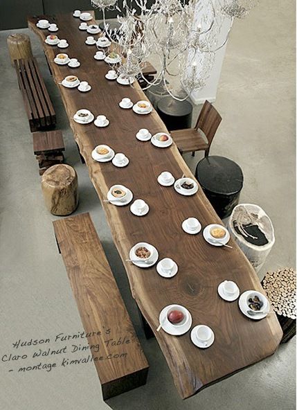 a long wooden table with plates and cups on it, sitting next to a bench