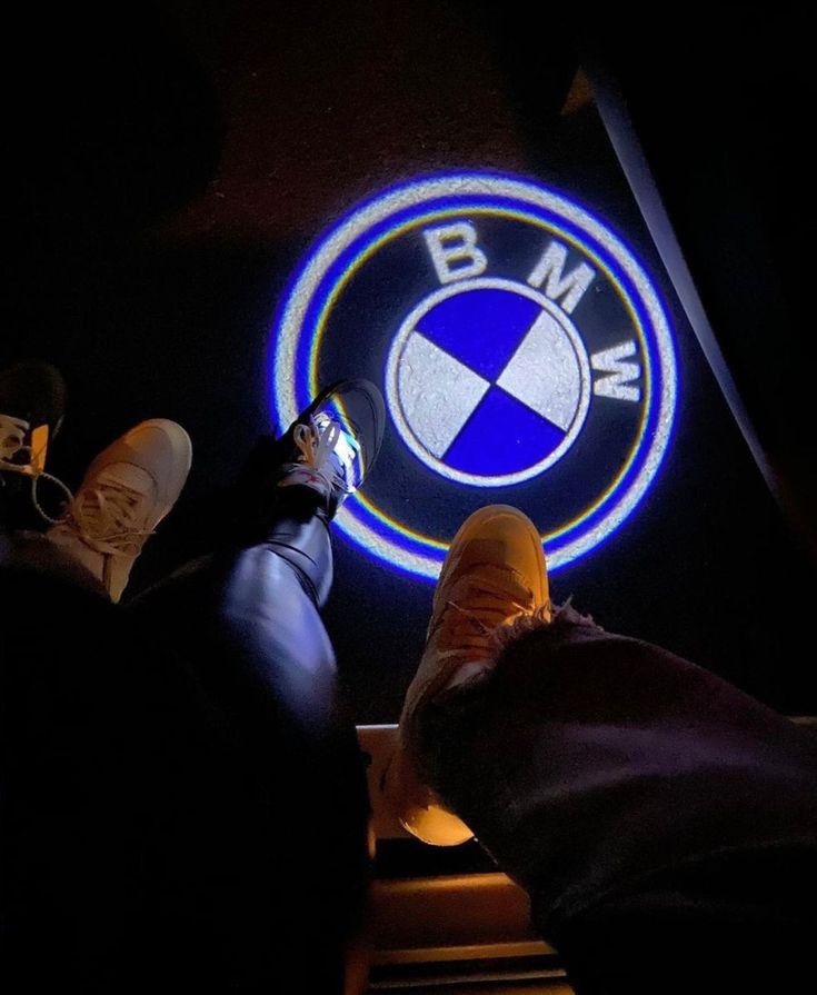 two people sitting in front of a bmw logo