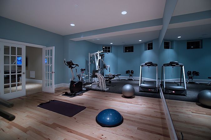 a gym with exercise balls, machines and other personal care items in the room at night