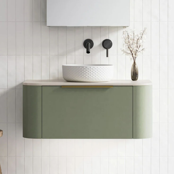 a white sink sitting on top of a green cabinet next to a wall mounted mirror