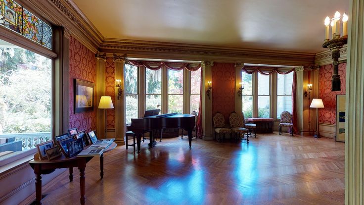 a living room filled with lots of windows next to a wooden floor covered in furniture