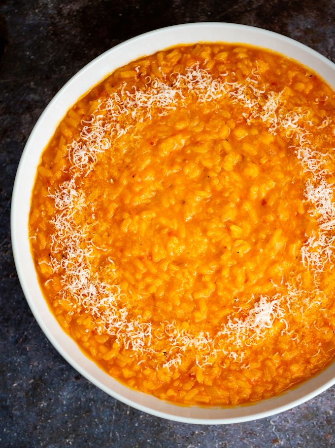 a white bowl filled with carrot soup on top of a table