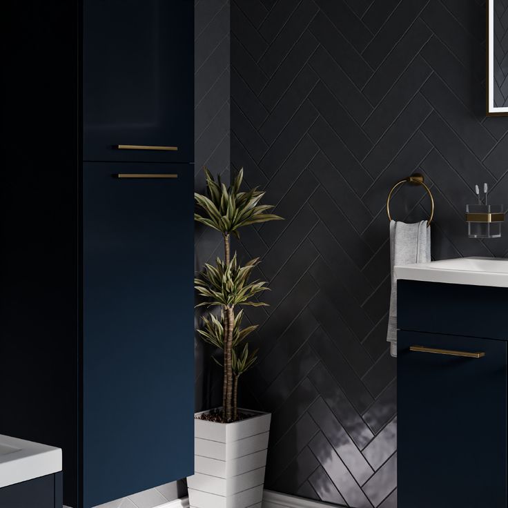 a bathroom with dark blue cabinets and white counter tops, along with a potted plant