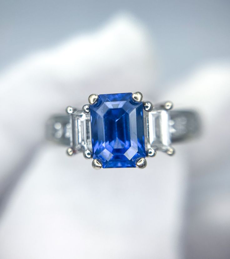 a blue and white diamond ring with three baguettes