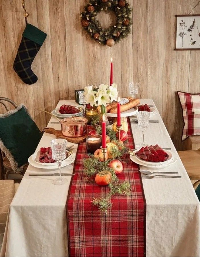 a christmas table setting with candles and fruit