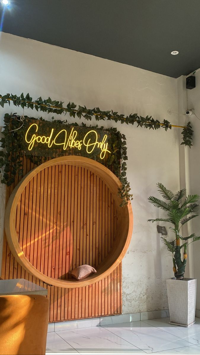 there is a sign that says good vibe day on the side of a wall with plants