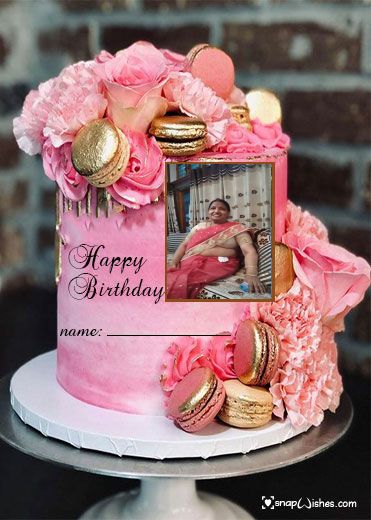 a birthday cake with pink frosting and gold decorations