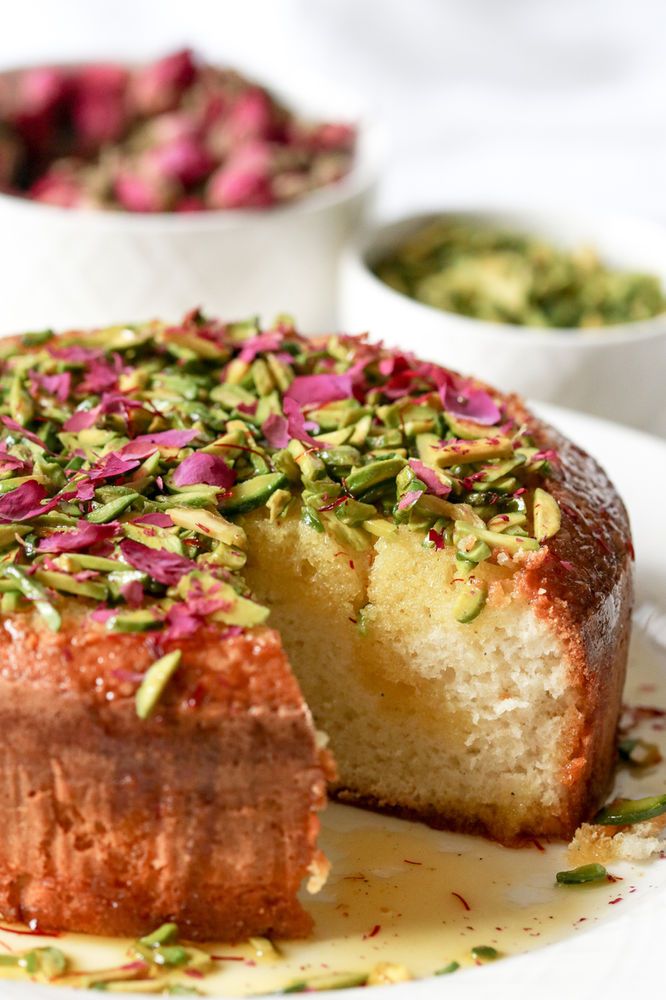 a cake on a plate with one slice cut out and sprinkled with flowers