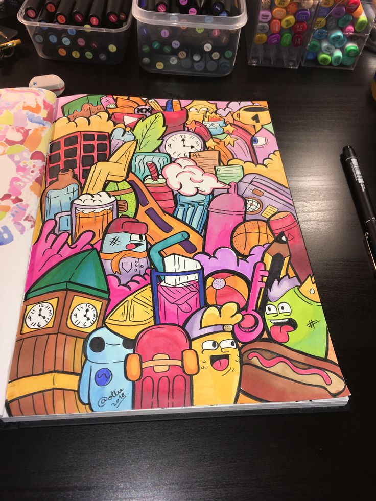 an open notebook on a table with markers and crayons