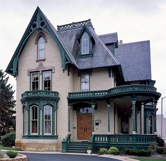 an old victorian style house with green trim