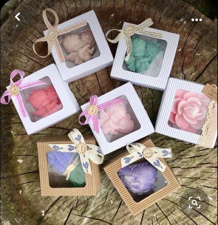 four small boxes with different colored soaps in them on top of a tree stump