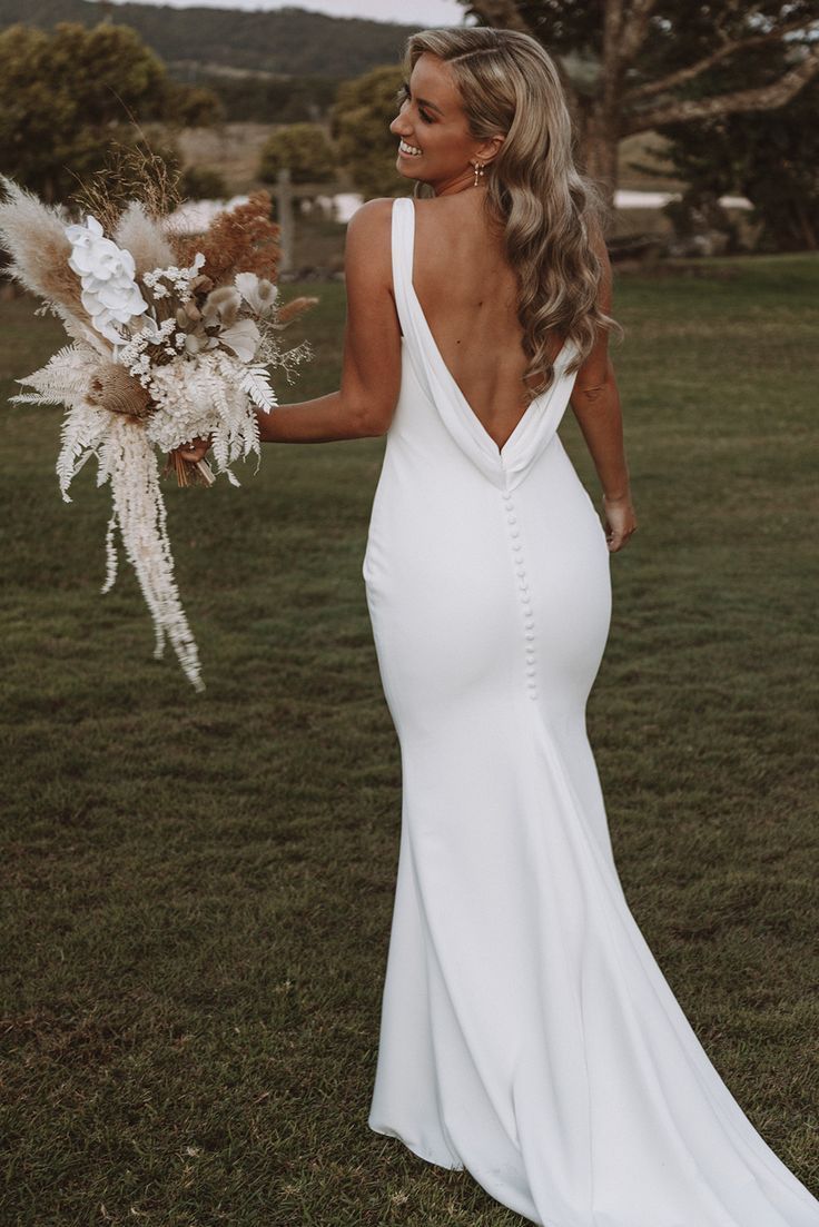 a woman in a white dress holding a bouquet