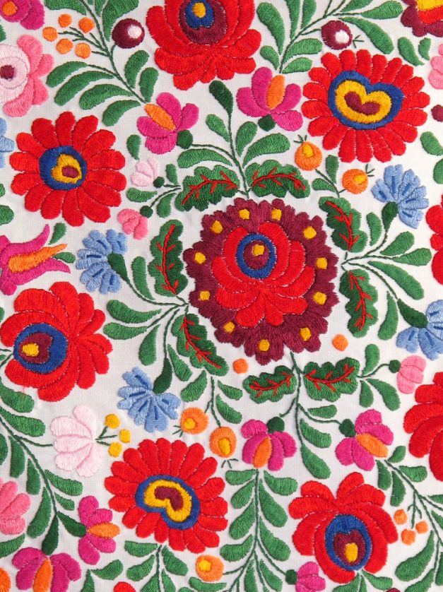 an embroidered cloth with flowers and leaves on it's side, showing the colors of red