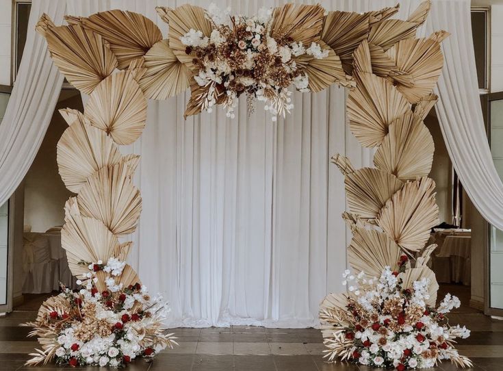 a wedding arch decorated with flowers and leaves