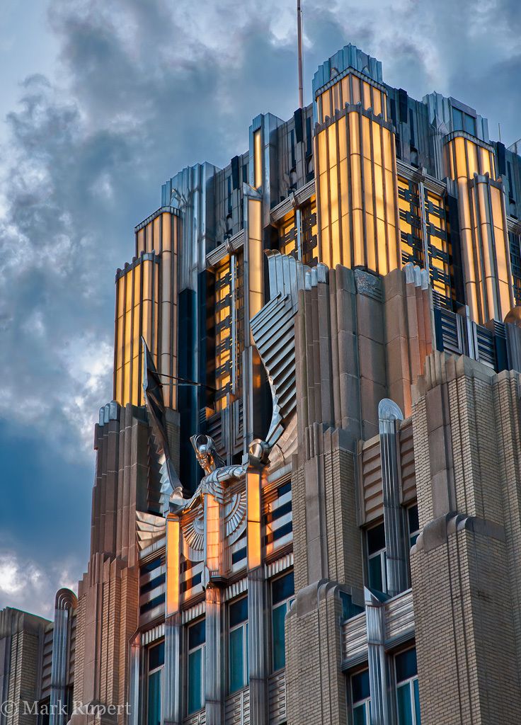 a very tall building with many windows on it's sides and a flag flying in the air